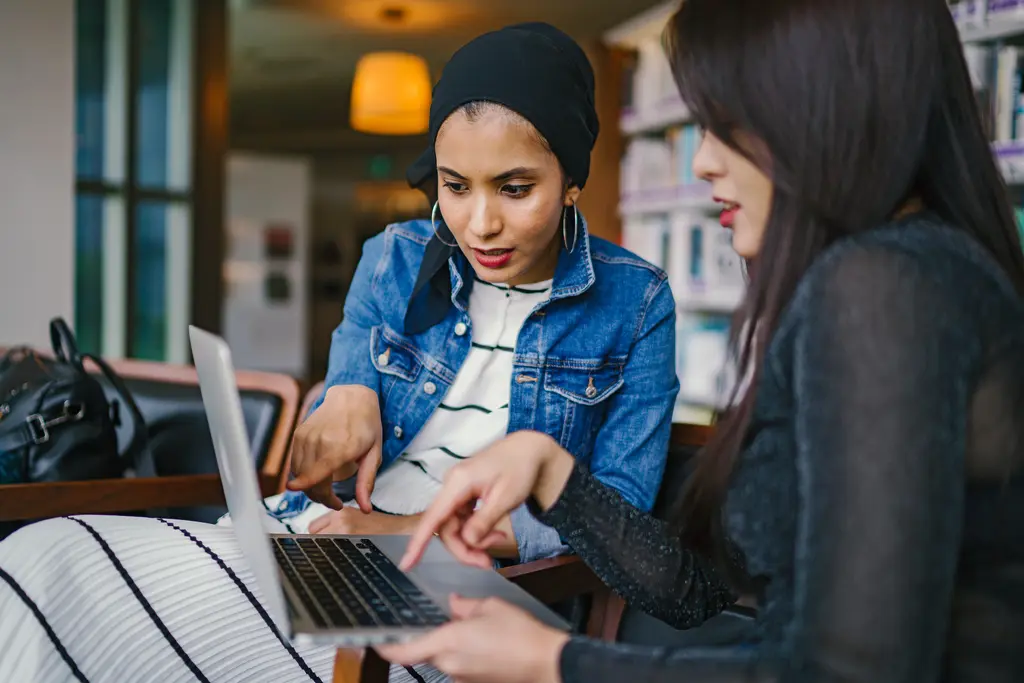 Two colleagues collaborating over a laptop