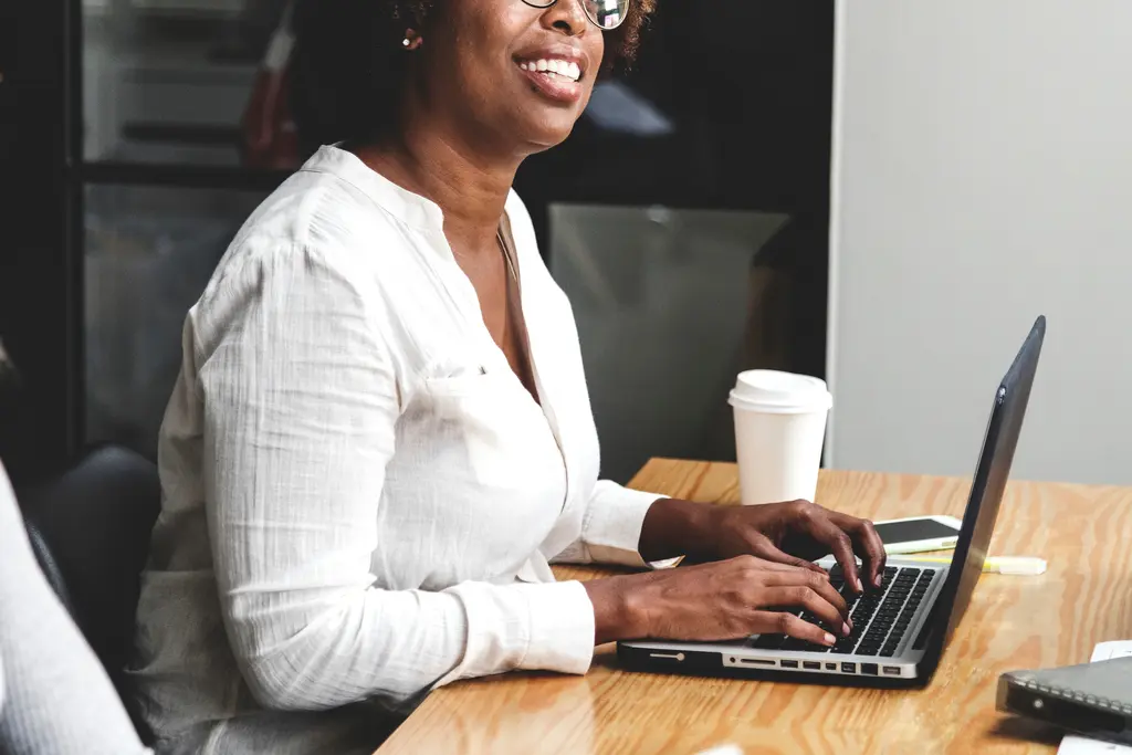 Woman smiling while working at a laptop